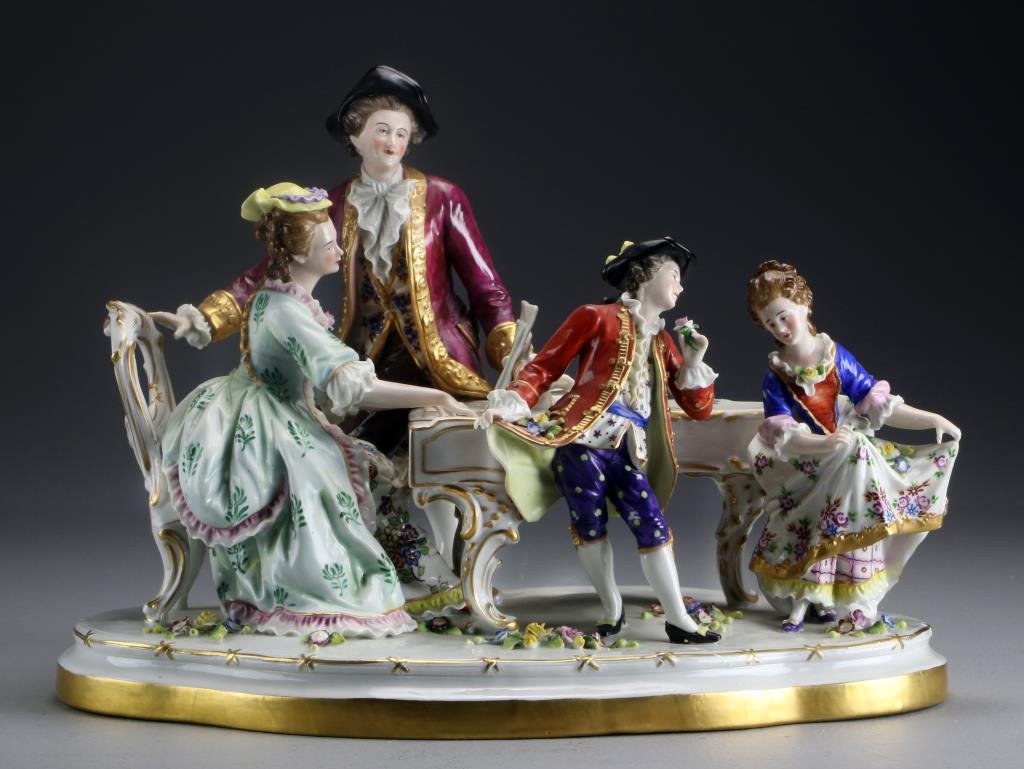 Dresden Quality German Porcelain Figural Group: Depicting a man and a woman playing the piano with children dancing, raised on scrolled and gilt plateau, underside with worn blue mark, measures 10"H x 14.5"L, circa late 19th-20th century. Good cond