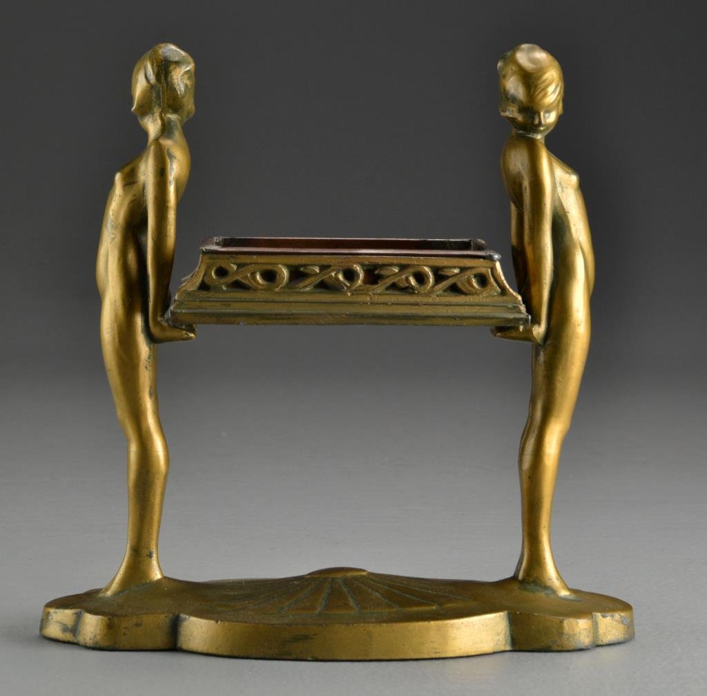 Frankart Art Deco Gilt Metal Figural Cigarette Stand: Depicting two beauties holding a basket, raised on shaped base, unsigned, probably Frankart, measures 9"H x 9.25"W, circa early 20th century. Property of a Washington, MI family.