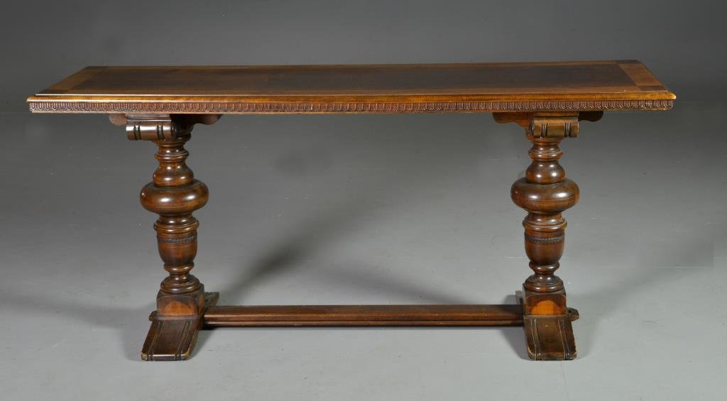 A Jacobean Style Carved Walnut Trestle Table: Having a rectangular banded top with carved edges, turned supports and trestle base, probably walnut 29" H x 65" L x 20" D, circa early 20th century. Condition, water glass mark, several areas of wate