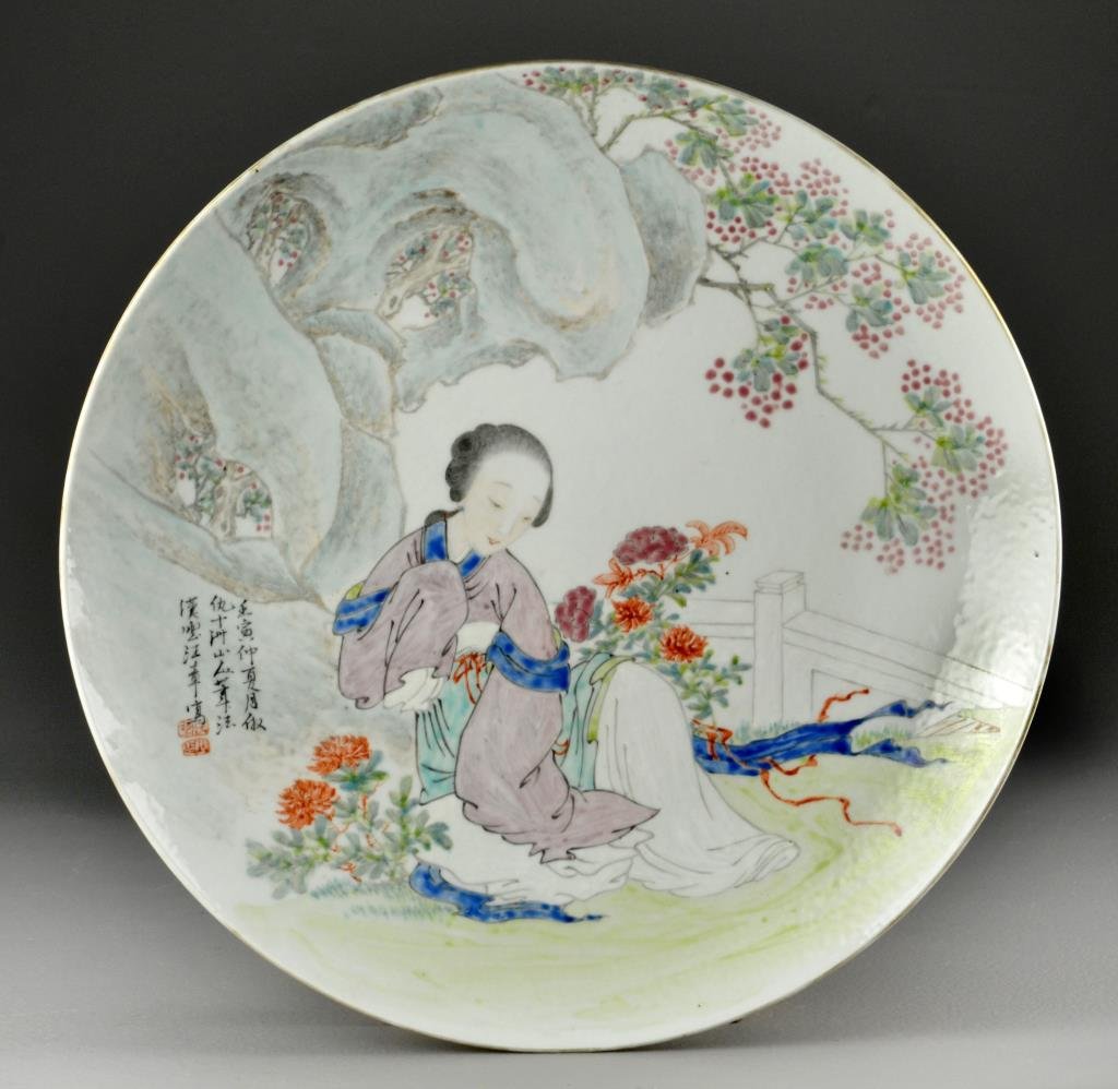 Large Chinese Famille Rose Porcelain Plate: Painted to depict a beauty in a court yard resting beneath a rocky outcrop, having several lines of calligraphy and red seals lower left, base four character marked in iron red, 2.25"H X 14.5"D, possi