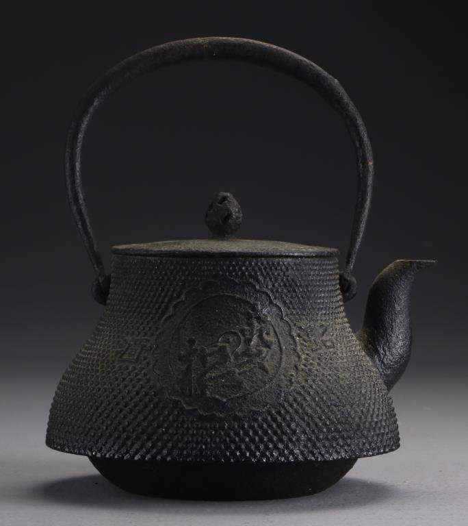 An Antique Japanese Cast Iron Teapot: Having a large character mark to one side flanked on either side by smaller character marks, the reverse with a row of calligraphy and artist seal, measures 9"H including the handle, possibly Meiji Pe