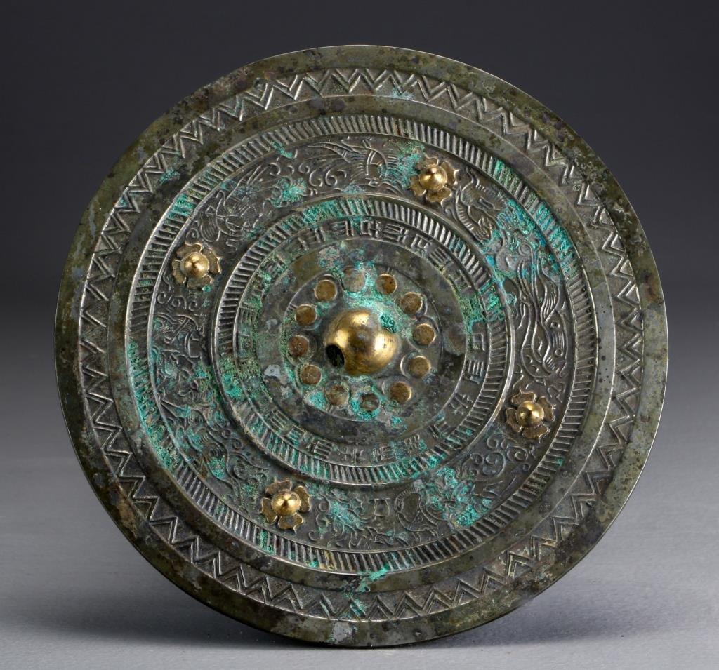 Chinese Tang Dynasty Bronze Mirror: Decorated in low relief with dragons, phoenix, and other animals, having a band of symbols near the center, some parts highlighted in gilt, 8.5"D, circa Tang Dynasty. Property of a private Michigan co
