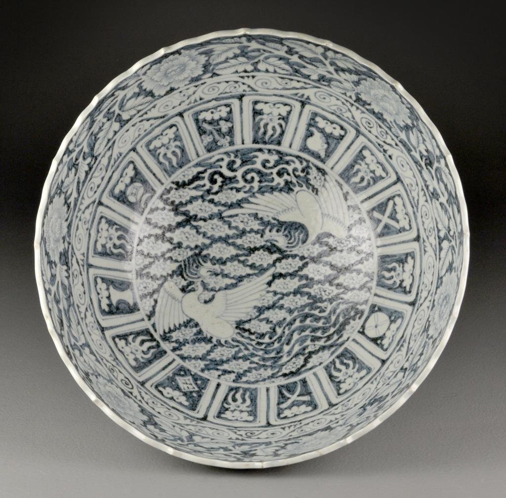Large & Fine Chinese Blue & White Porcelain Bowl: The outside painted to depict a forest landscape, the interior depicting opposing phoenix amongst ruyi clouds bordered by Buddhist symbols, with foliate rim and raised on short foot, 7.25"H X 15.75"D.