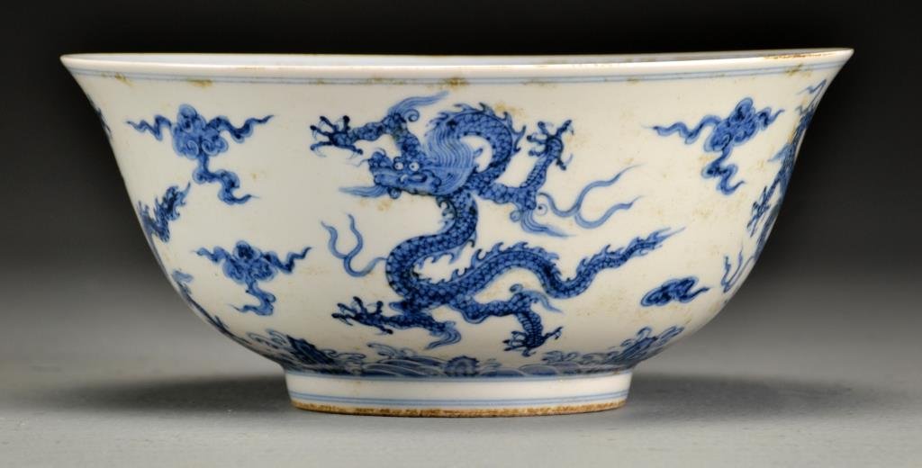 Chinese Blue & White Porcelain Bowl: The interior with five character marks and a dragon amongst ruyi clouds at center, the exterior dragons amongst ruyi clouds above crashing waves, raised on short foot ring, base having six character m
