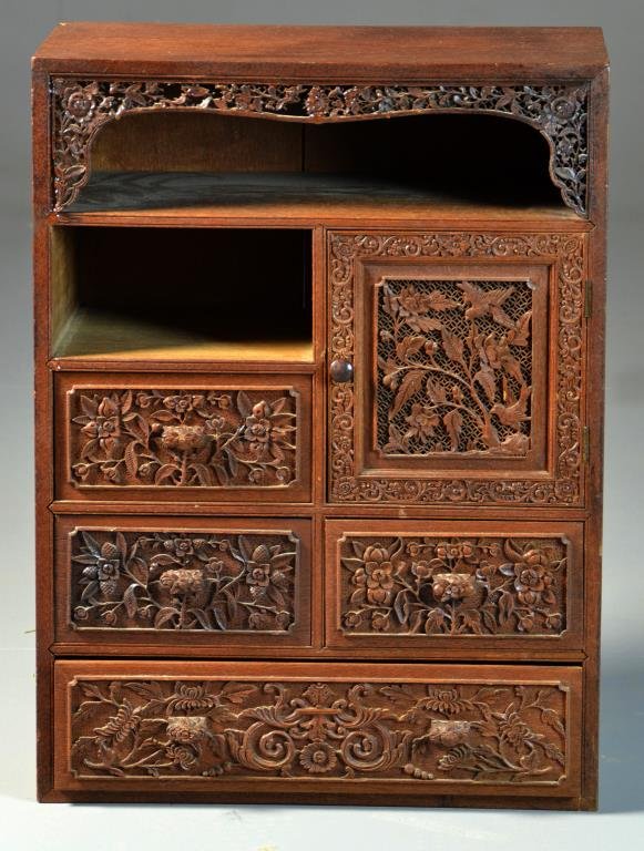 Finely Carved Chinese Table Cabinet: Having four drawers and one small door, carved all over with depictions of birds and scrolling floral decoration, possibly teak wood, measures 24"H x 18"W x 10"D, circa late 19th-early 20th century. C