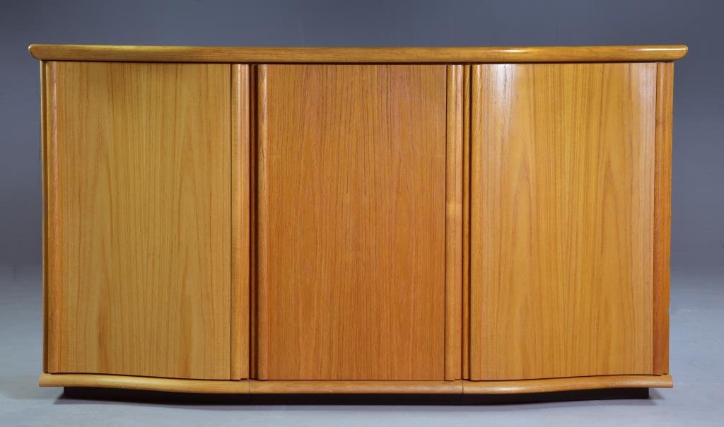 Skovby Denmark Teak Three Door Buffet: Having a shaped top above three doors opening to reveal shelves and two roll out slides, measures approximately 33"H x 60"L x 19.75"D, circa 20th century, paper label marked Skovby Denmark to back of 