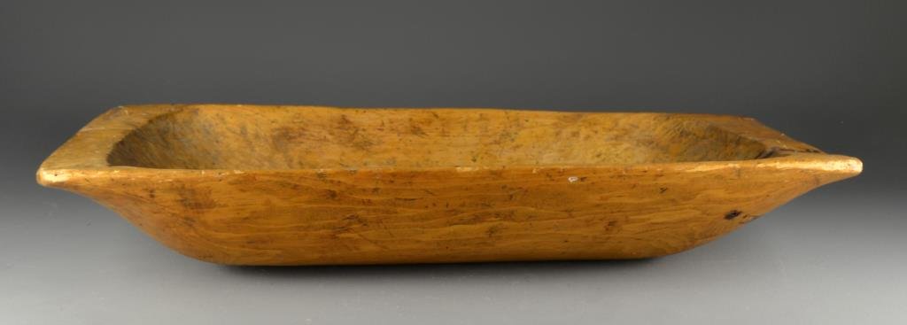 Large Primitive Dough Bowl: Trench formed dough bowl with beautiful patina, measures approximately 38"L x 18"W, circa late 19th century. Condition: having one interior age split.