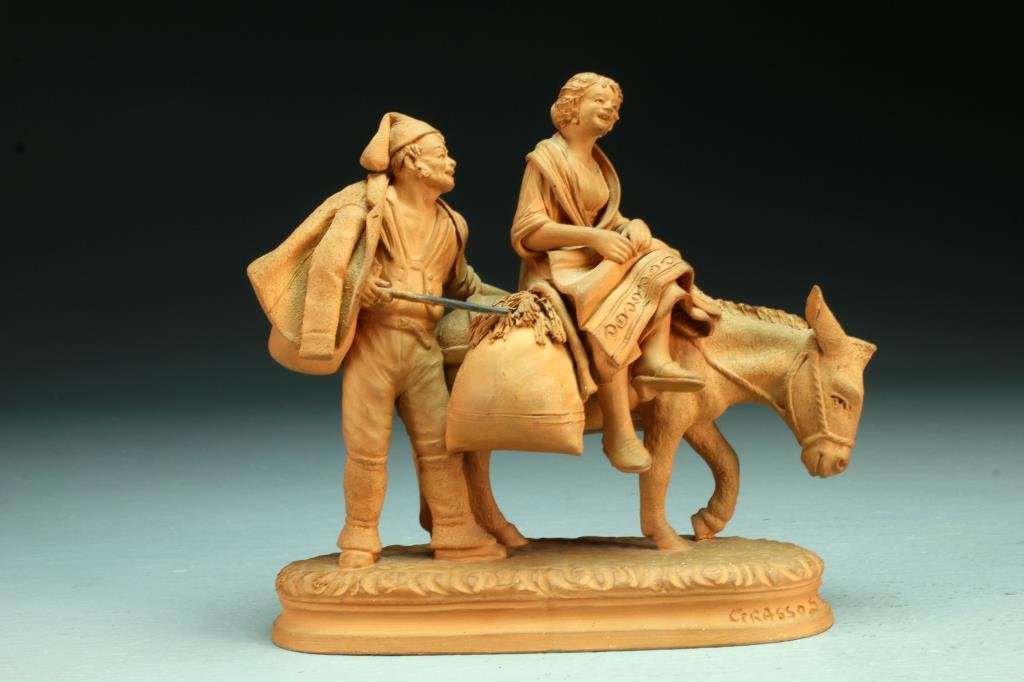 Grasso Italian Redware Figurine: Finely rendered to depict a male figure with a woman seated on a mule, signed "Grasso S. No" to front right of base, measures 6"H, circa 20th century. Condition, mule lacking one ear.