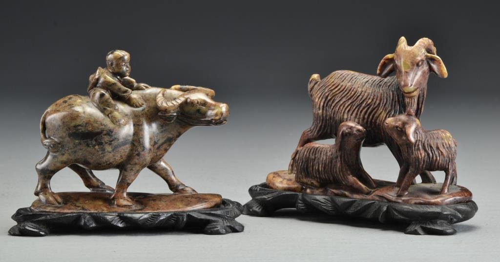 (2) Chinese Finely Carved Soapstone Groupings: One depicting a goat with her offspring, the other depicting a buffalo and boy, both raised on fitted wood stands, one ethced China to base, one signed with two or three character mark to base, larges