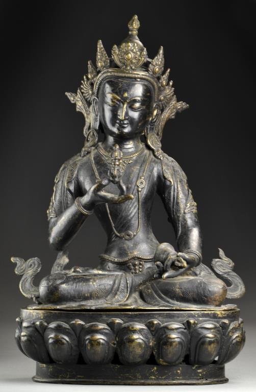 Large Antique South East Asian Bronze Buddha: Finely formed of two separate pieces comprising the base and statue itself, depicting a Buddha seated on a lotus throne holding a bell in one hand and a vajar in the other, a very well cast statue ret