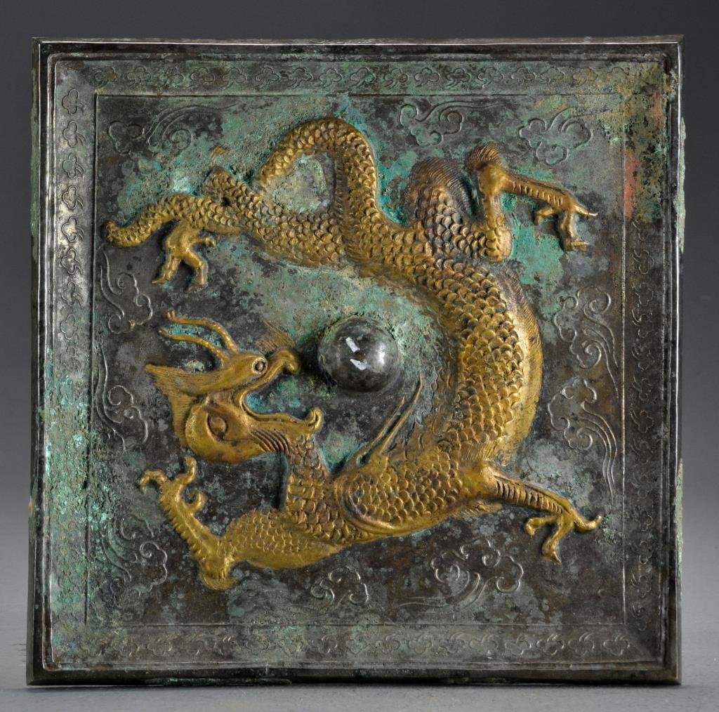 Chinese Archaic Style Bronze Mirror: A square silvered bronze mirror decorated with ruyi clouds, the center with gilt highlighted three clawed dragon, measures 10.25"sq.