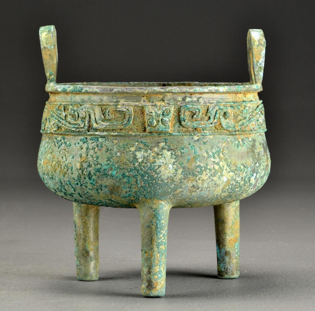 Chinese Archaic Style Bronze Censer: Raised on tripod feet, the body decorated with symbols and animal faces, having two bail handles rising from the body, 7.125"H, archaic style but probably 19th/20th century.