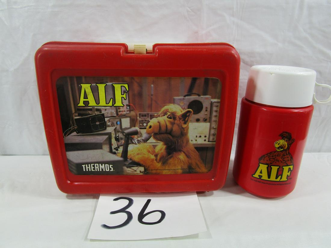 1987 Alien Productions Alf Lunch Box: This Alf lunchbox comes with the original thermos. It is about 6.5" tall and 3" diameter. The finger ring on one side is cracked. The lunch box measures about 7" tall, 8.5" wide and 4" thick. It has s