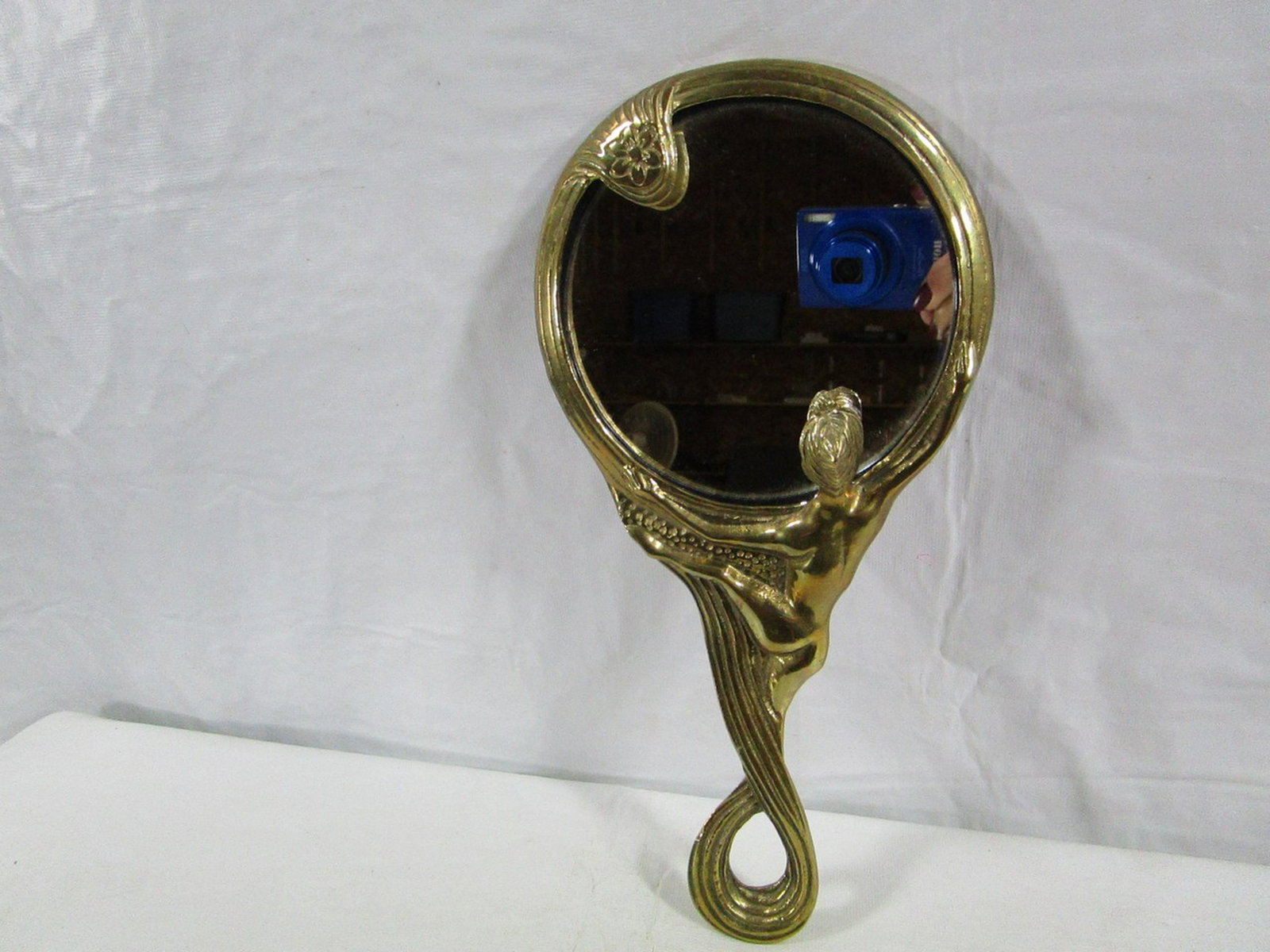 Art Nouveau Hand Mirror Nude Lady: This mirror so unique and heavy made. The lady looks in the mirror at her reflection. Her head is raised and dimensional. It measures about 10.5" tall and 5" diameter. No chips or cracks. The gold ton