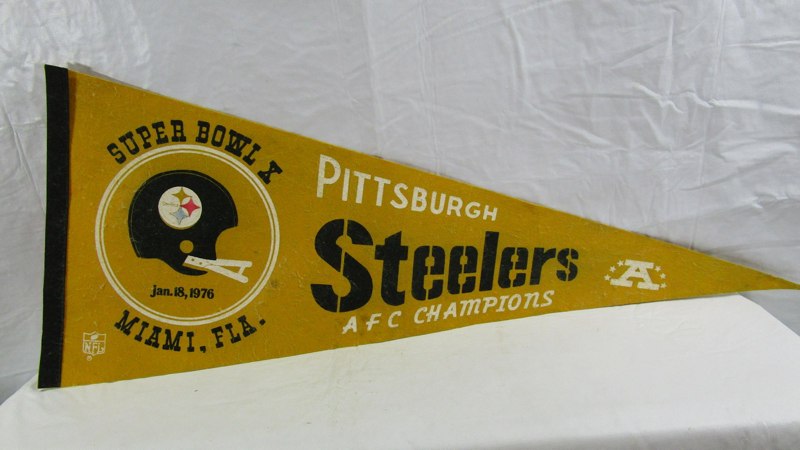 Super Bowl X Champions AFC Steelers 1976 Pennant: This pennant is about 30" long and 12" wide at the widest area. It has pilling and some stains here and there. It is dated Jan. 18, 1976.