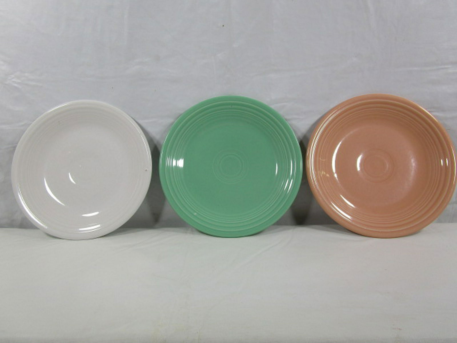 Lot Of 3 Fiestaware Fiesta 7" plates: This lot includes three 7" plates in the following colors, Sea Mist, Apricot & White. They have some surface scractching, please view the pictures for a better understanding of their condition. No chi