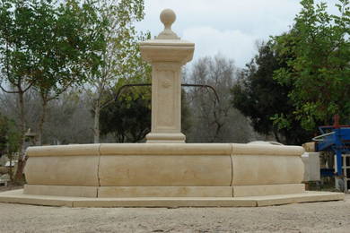 Provence stone fountain with iron spouts and pedestal