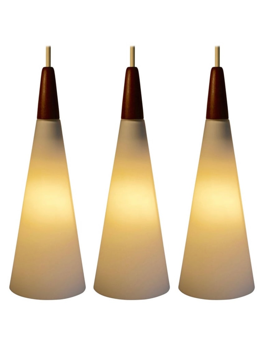 Three Mid Century Modern White Satin Glass and Teak Pendant Lights, Finland: Set of 3 Mid-Century Modern white satin glass and teak cone shaped pendant lights made in Finland by Holmegaard, circa 1960. Nice large size. Excellent condition. All original. 15.50" tall x 5" diamet