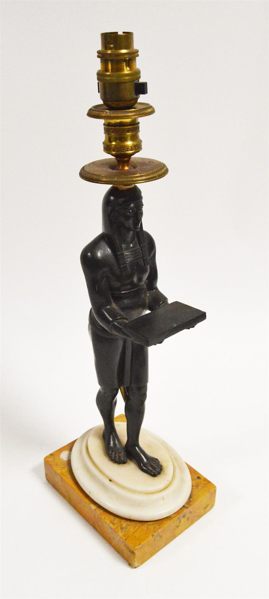 A French Empire candlestick converted to electric table: A French Empire candlestick converted to electric table lamp, in the form of a patinated bronze Egyptianesque male figure supporting an ormolu sconce, raised on white marble base and orange marble pli