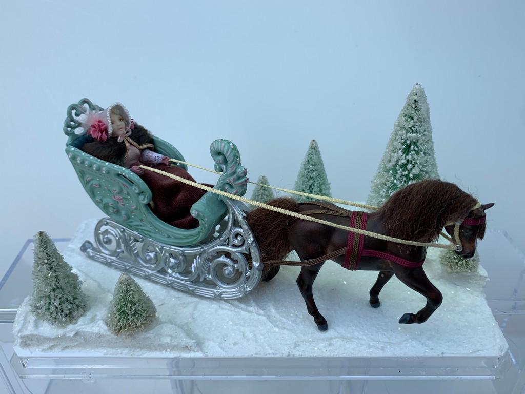 Denise Pritchett Horse Drawn Sled w/ Girl Doll: #2 of 4 Made by Denise S. Pritchett. Horse drawn sleigh with hand made porcelain doll. There's snow on the ground and trees around. The plexiglass cover is removable. The horse is brown.