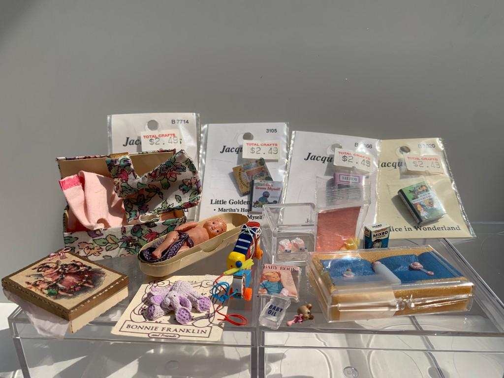15 + Nursery & Baby Accessories Lot - 1" Scale: This is a baby / nursery lot with a variety of children's books, a tiny plastic baby, bottle, pacifier, tiny baby bunny slippers, box with clothing, helicopter pull toy, shoe pull toy, purple bunny ra