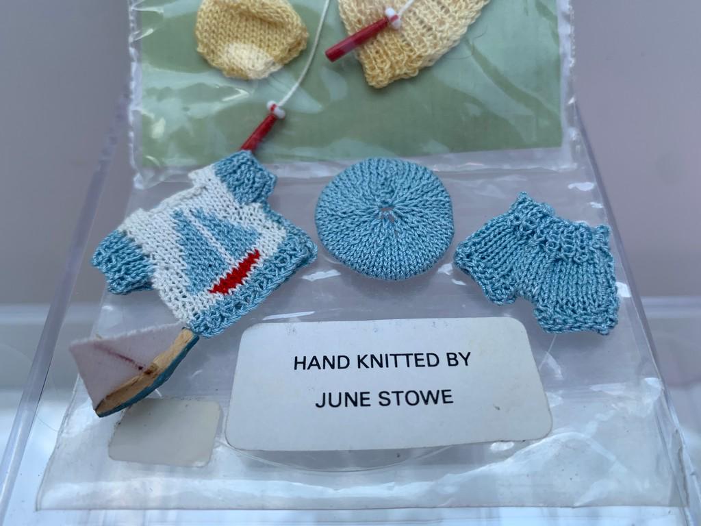 June Stove Hand Knit Childs Yellow & Blue Outfits: Hand knit set of child's sweater, pants and hat in blue with a matching boat. The yellow set is a child's skirt, hat, sweater and jump rope. A boy and girls outfit. Dollhouse miniature, 1:12 scale