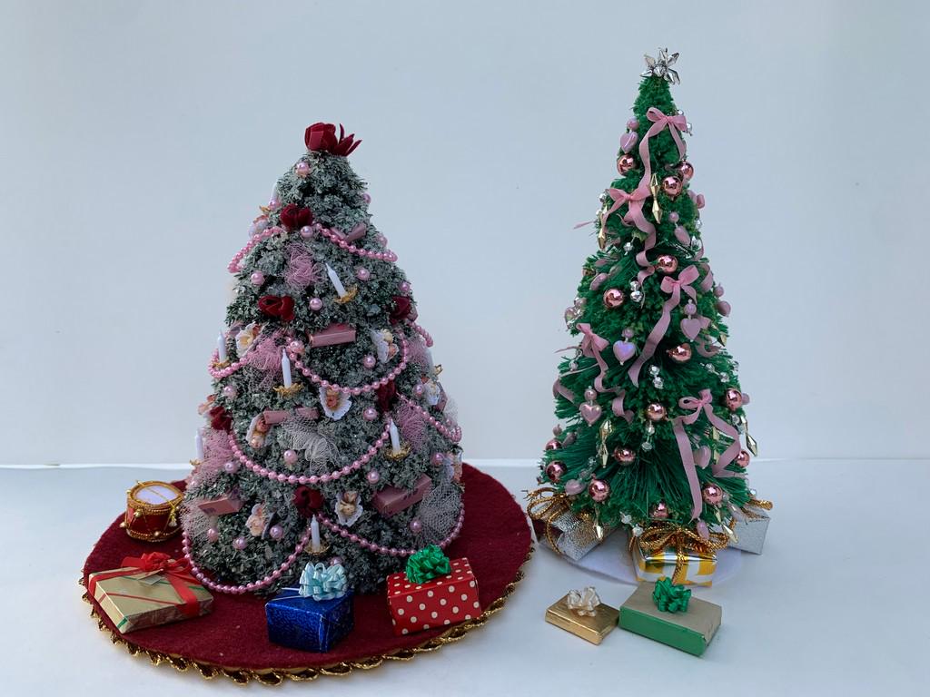 2 Decorated Christmas Trees w/ Presents: The Christmas trees are decorated with pink baubles, and come with a tree skirt and presents. The trees are decorated differently. One tree is taller and more narrow, the other fuller and branches are