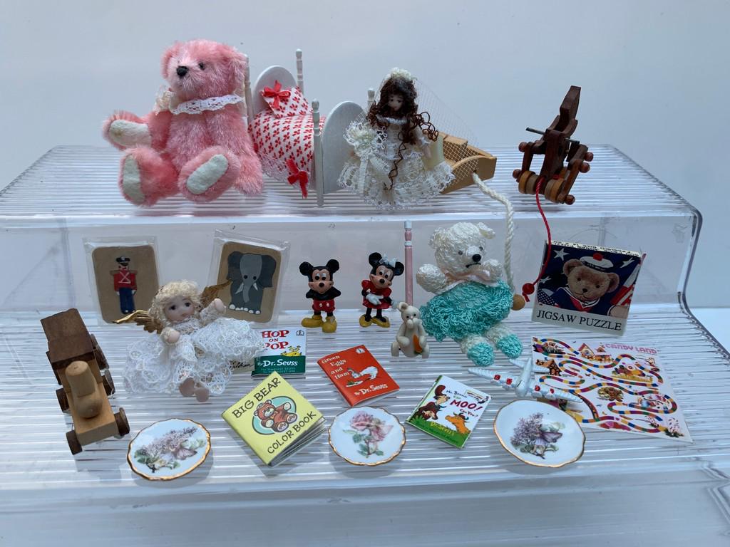 Toy / Play Room with 18+ Toys For Children: This lot has a hand crafted doll dressed as a bride and a hand crafted doll dressed as an angel. In addition, a dolls bed, large teddy bear that is hand crocheted, wooden horse pull toy, bunny toy mis