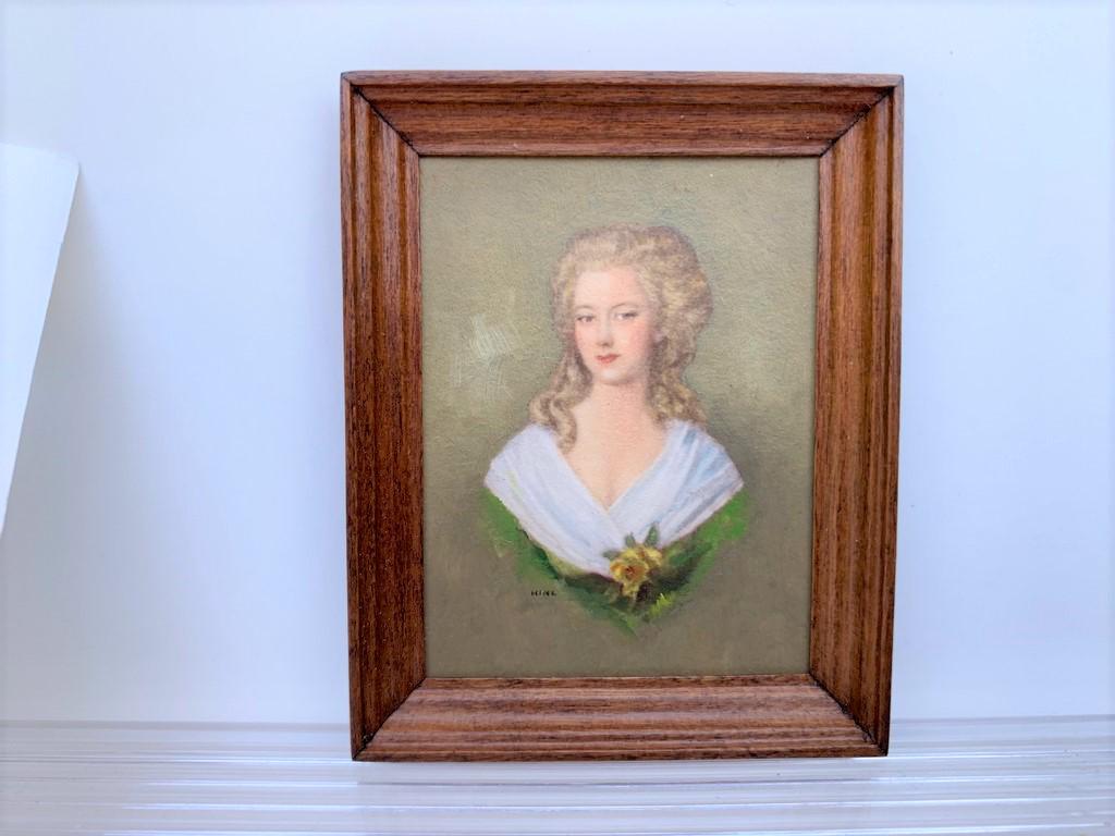 IGMA Margaret Nine Painting & Roger Gutheil: 2 IGMA artisans. The beautiful poitrait of a young lady is painted by Margaret Nine. She's wearing a green dress with her blonde hair semi pulled up and a has a yellow flower. The frame is made by the