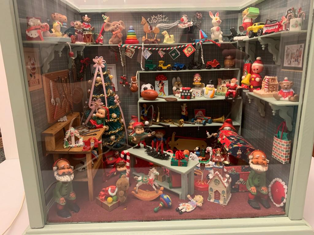 Decorated Christmas Room Box Filled w/ Toys!: This is a decorated room box filled with Christmas spirit. There are toys, a Christmas tree, Santa's workbench, a trunk, and more toys. The Christmas tree lights up if you use a 12 volt transformer, t