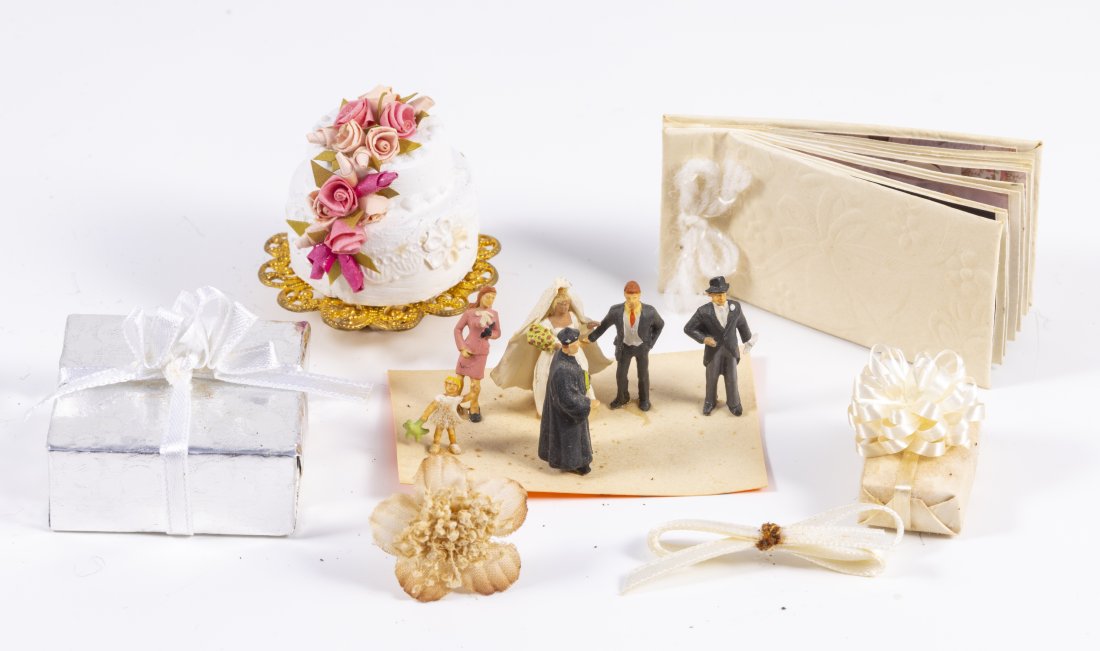 Wedding Day Celebration in Miniature: Handmade wedding cake decorated with pink flowers, a photo album, presents and little groom, bride, minister, little girl and woman and man in top hat. Cake: 1 1/2" tall