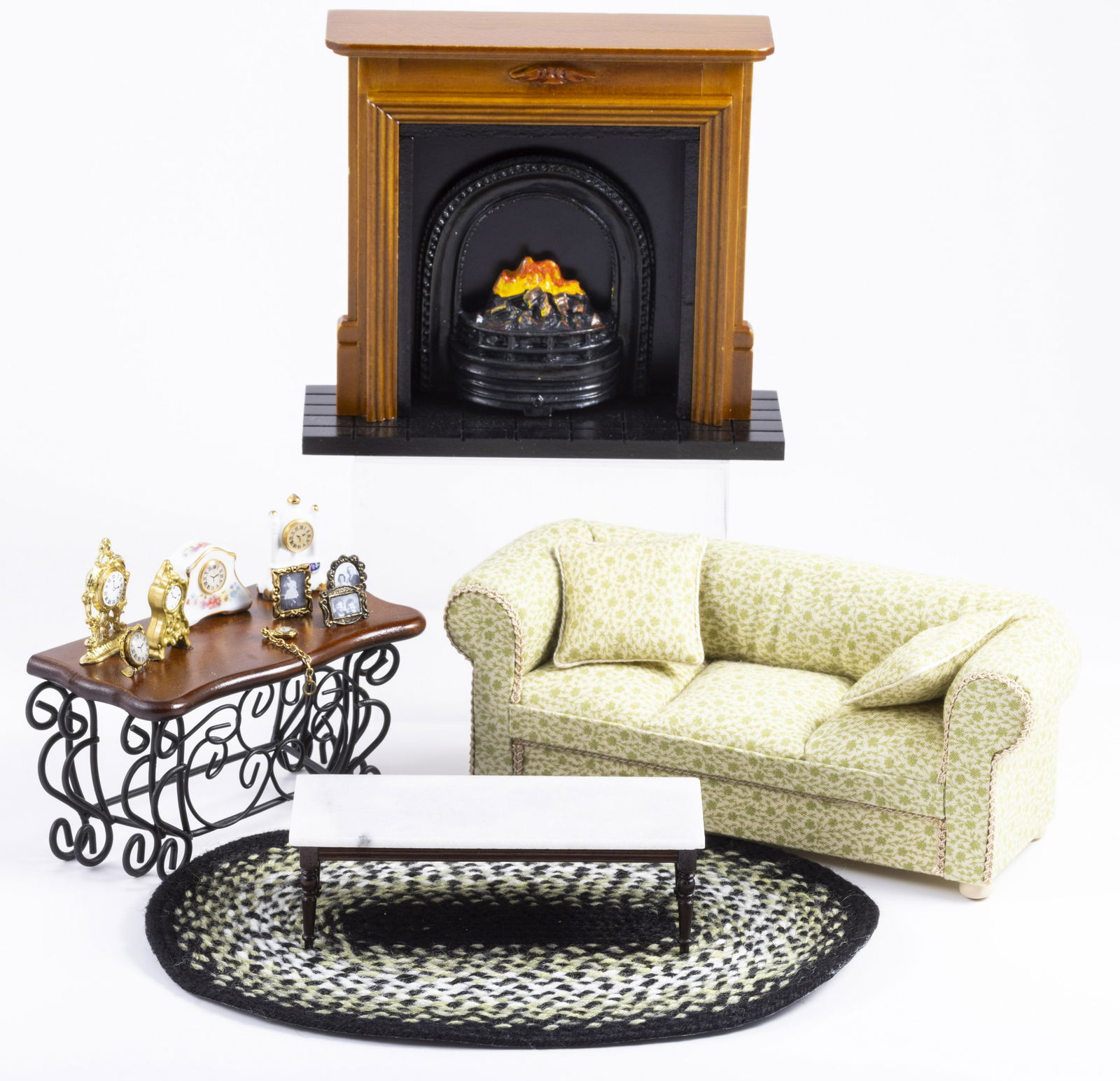 Living Room Sofa with Fireplace & Decorated Reutter Clock Table: Living room sofa with a handmade green floral couch, handmade oval braided rug with greens and black colors. There's a Reutter Porcelain side table with a variety of clocks, a coffee table with a faux