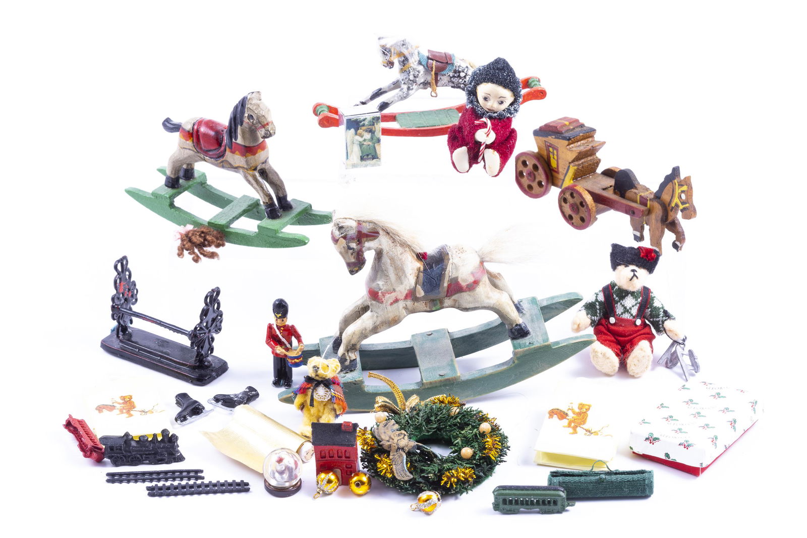 Christmas Toys Galore: Rocking horses, train, wreath, teddy bear in hat, teddy bear in scarf, horse and buggy made of wood, and more Christmas toys.