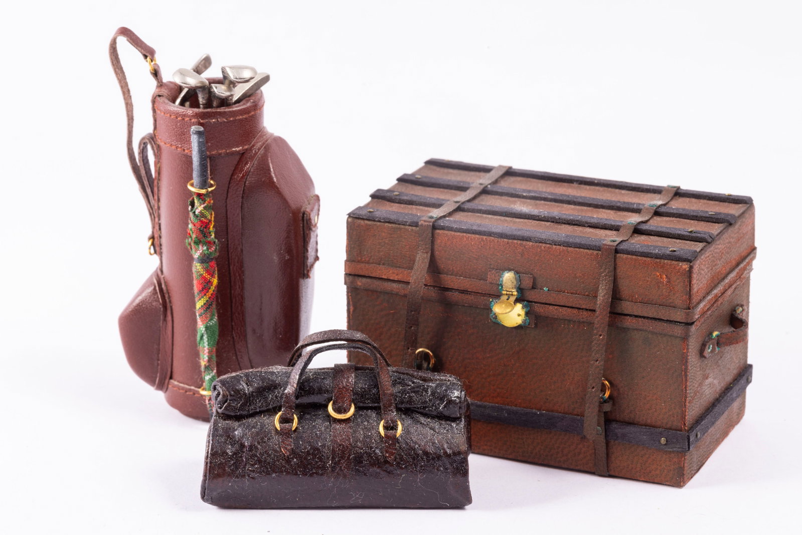 Leather Trunk & Travel: leather trunk with lining inside, as well as a leather golf bag and satchel. The golf bag has removable golf clubs, the satchel does not open and is made of leather. The trunk opens.