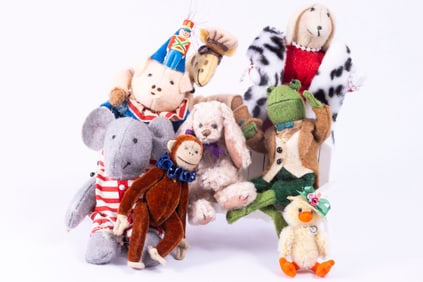Large Assortment of Large Stuffed Animals on Bench