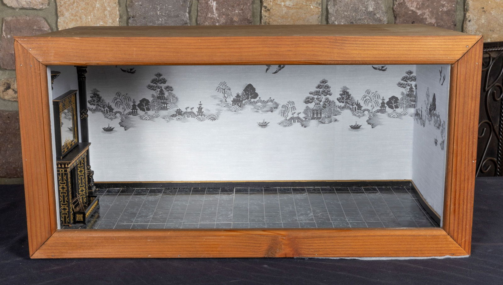 Asian Inspired Roombox with Black & Gold Fireplace with Mirror: Asian inspired roombox with an Asian mural wallpaper. Black floor tile in a wooden roombox. There's a black and gold fireplace with matching mirror. There's two columns next to the fireplace.Measureme