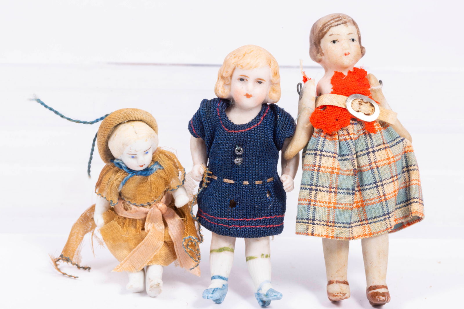 3 Little Girl Antique Bisque Dolls: 3 Little girl antique bisque dolls. All dressed in old fashioned clothing. Dolls are 2 1/4" tall for smallest doll, and the tallest about 3 1/4" tall. Approximately 80-100 years old.