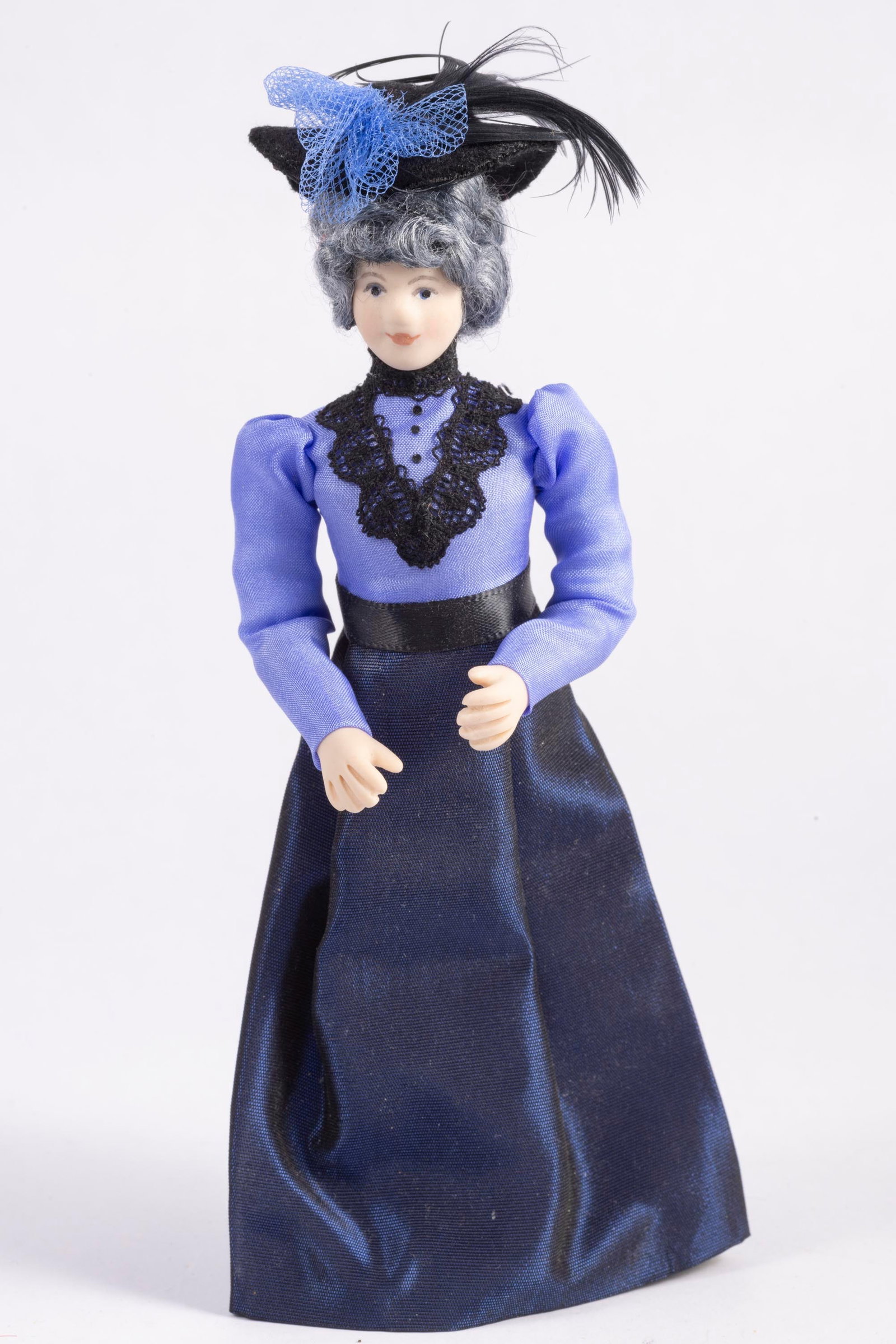 Lady Doll Dressed In Purple: Porcelain lady doll dressed in a purple dress with a hat. Nicely made.
