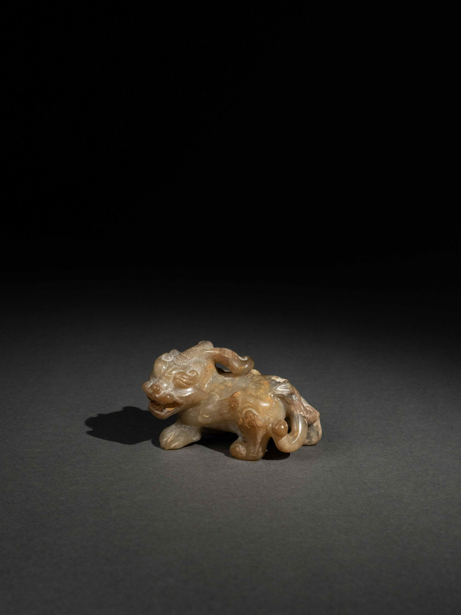 A PALE CELADON JADE FIGURE OF A BIXIE (1 of 4)