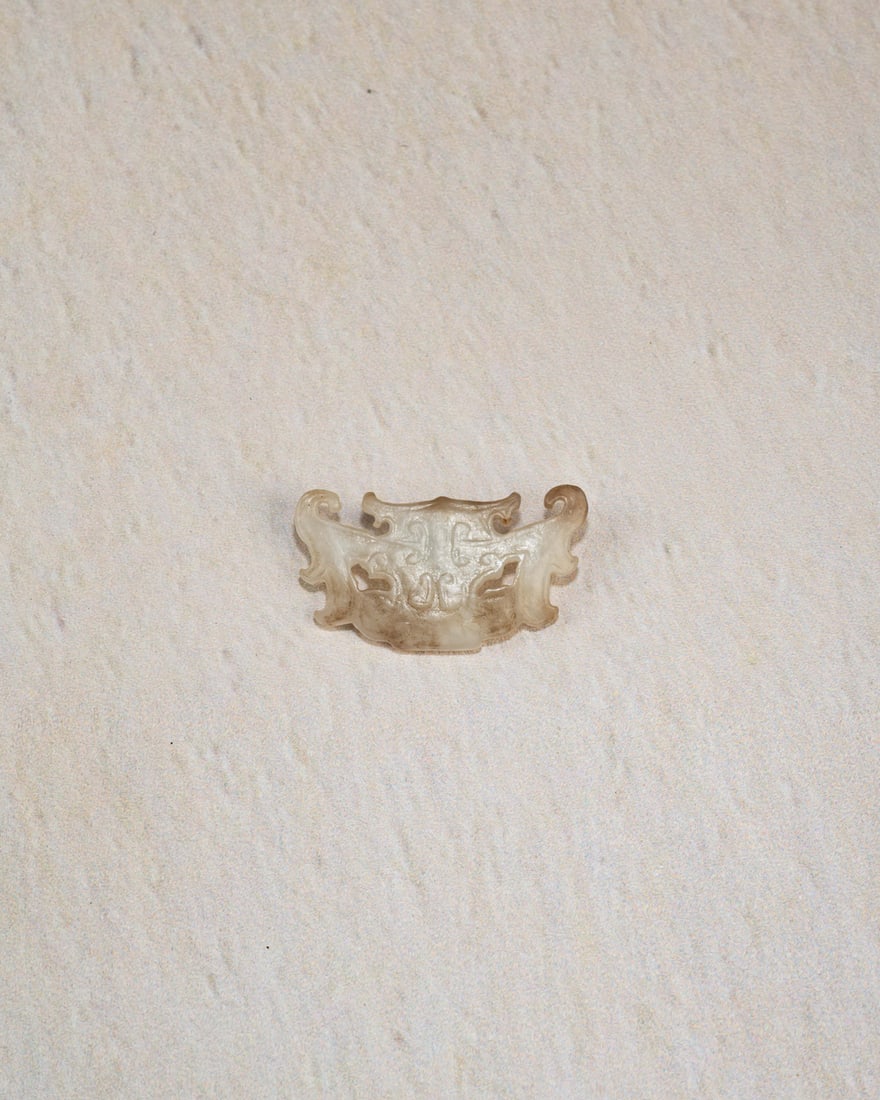 A JADE 'HUMAN MASK' ORNAMENT: 品名(title):石家河文化 玉神人面冠飾。年代(Age): NEOLITHIC PERIOD。 尺寸:4.3 cm Length,