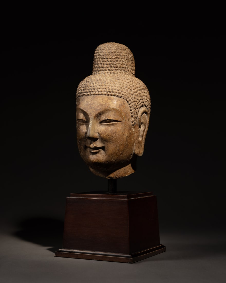 A CARVED STONE HEAD OF BUDDHA: 品名(title):北魏 石雕佛首。年代(Age): NORTHERN WEI (386-535 A.D.)。 尺寸:24.2 cm Height。 參閱A