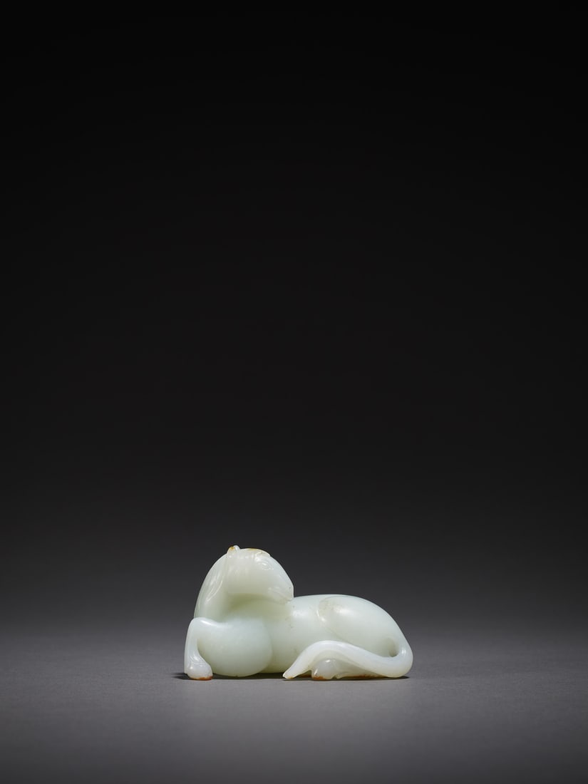 A WHITE JADE CARVING OF A HORSE: 品名(title):清乾隆 帶皮白玉臥馬。年代(Age): QIANLONG PERIOD, QING DYNASTY。 尺寸:9.5 cm Length, 4.