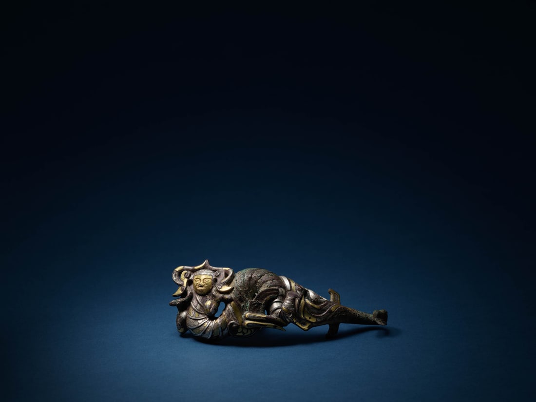 A GOLD AND SILVER-INLAID BRONZE BELT HOOK: 品名(title):戰國 銅錯金銀帶鉤。年代(Age): WARRING STATES PERIOD (475-221 B.C.)。 尺寸:18.8 cm Length