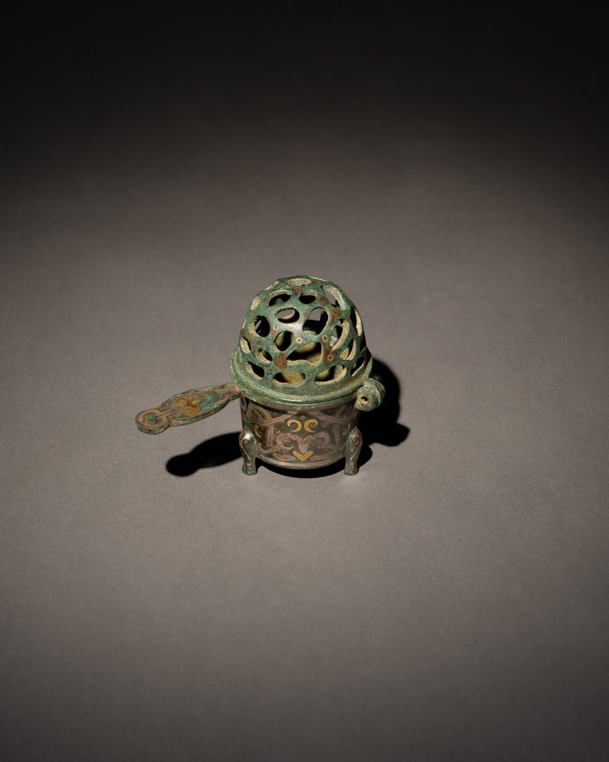 A GOLD AND SILVER-INLAID BRONZE CENSER: 品名(title):戰國 銅錯金銀小行爐。年代(Age): WARRING STATES PERIOD (475-221 B.C.)。 尺寸:10 cm Leng