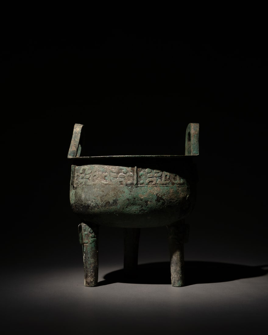 A BRONZE RITUAL TRIPOD FOOD VESSEL, DING (1 of 3)