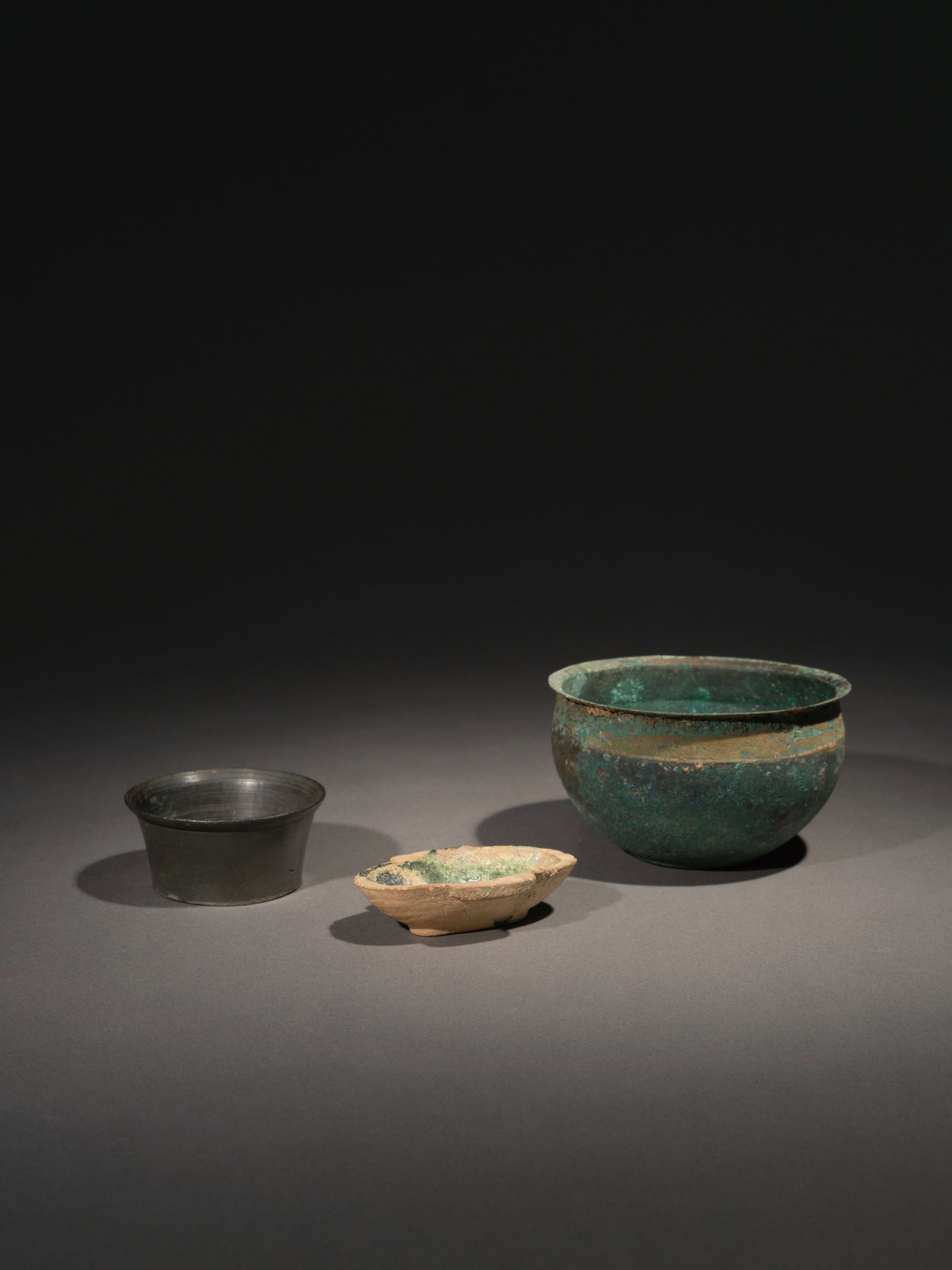 A SMALL BRONZE POT, A GREEN-GLAZED CUP AND A BRONZE 'ZEN' VESSEL: 年代(Age):HAN TO TANG 。尺寸(Size):6.2 cm Diameter, 3 cm Height / 6.9 cm Length / 9.8 cm Diameter, 5.7 cm Height。 來源：台灣資&