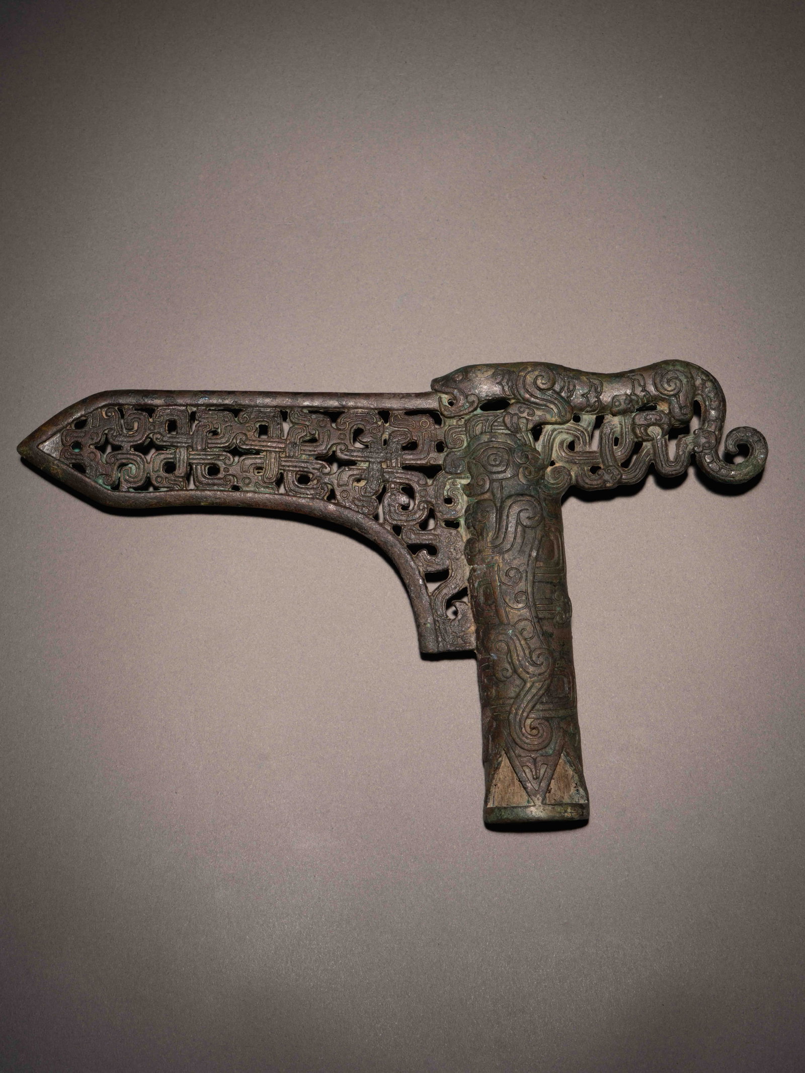 A BRONZE OPENWORK 'TIGER' DAGGER-AXE, GE: 年代(Age):WARRING STATES PERIOD(475-221 B.C.) 。尺寸(Size):19.6 cm Length, 12 cm Width。 來源：中國嘉德香港