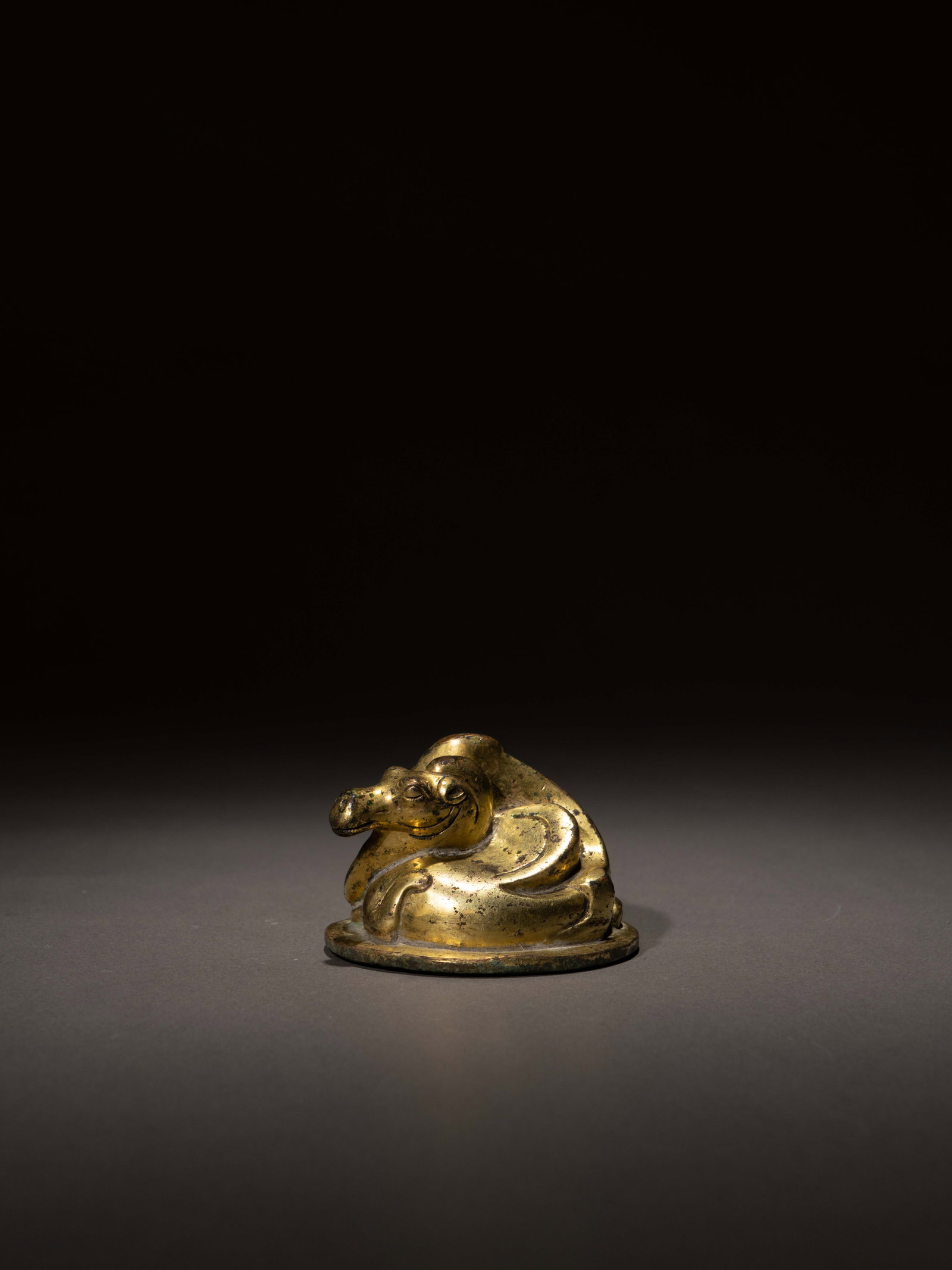A GILT-BRONZE 'CAMEL' WEIGHT: 年代(Age):HAN(206 B.C.-220 A.D.) 。尺寸(Size):6.7 cm Diameter, 4.6 cm Height。