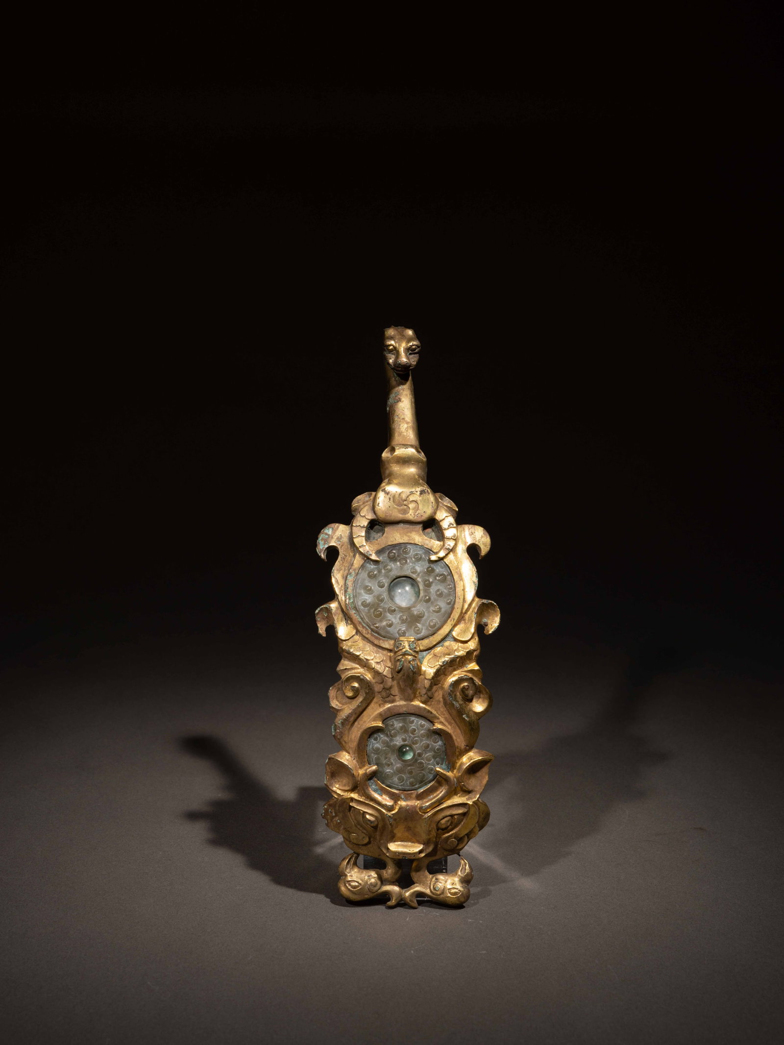 A JADE AND GLASS-INLAID GILT-BRONZE BELT HOOK: 年代(Age):HAN(206 B.C.-220 A.D.) 。尺寸(Size):22.1 cm Length, 5 cm Width。