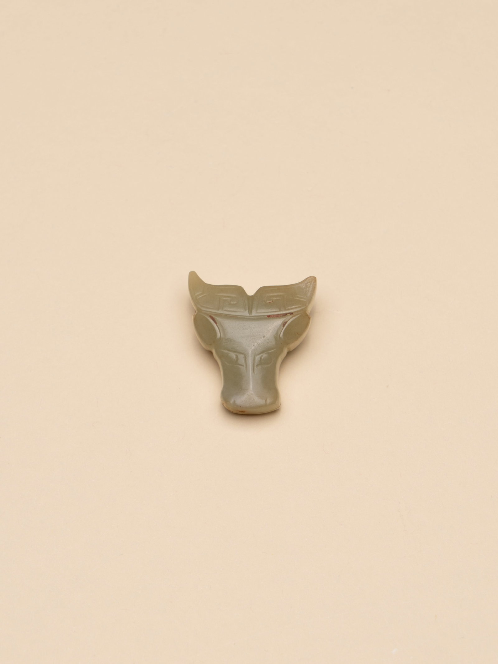 A JADE HEAD OF AN OX: 年代(Age):SHANG(1600 B.C.-1046 B.C.) 。尺寸(Size):3 cm Width, 3.4 cm Height。 參閱：1. 西周早中期 牛頭&#
